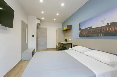 a bedroom with a white bed and a painting on the wall at Roma Vaticano Deluxe in Rome