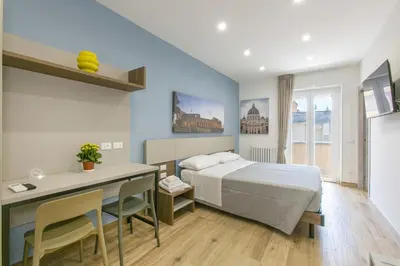 a bedroom with a bed and a desk and a table at Roma Vaticano Deluxe in Rome