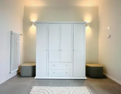 a large white cabinet with two stools in a room at Beautiful Penthouse Roma in Rome