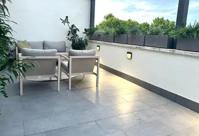 a patio with a table and chairs and plants at Beautiful Penthouse Roma in Rome