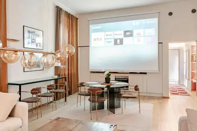 a large screen in a living room with a table and chairs at Unique Piazza Navona 2 Bedrooms and Home Cinema in Rome