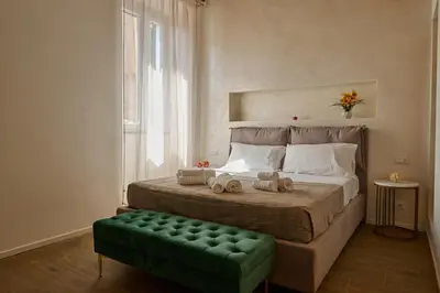 a bedroom with a large bed with a green ottoman at BellaRoma NAVONA Guest house in Rome