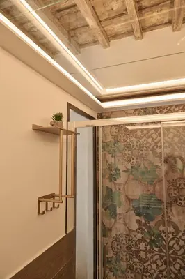 a bathroom with a shower with a large painting on the wall at BellaRoma NAVONA Guest house in Rome