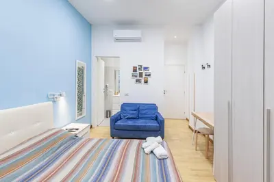 a room with a bed and a blue chair at Alloggi Costantini - Ospedale Gemelli - Metro Battistini in Rome