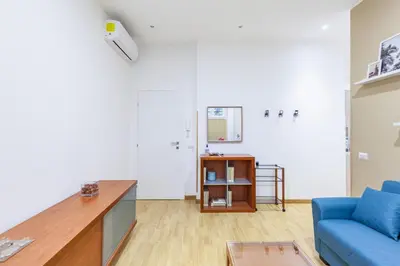 a living room with a blue couch and a table at Alloggi Costantini - Ospedale Gemelli - Metro Battistini in Rome