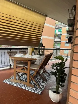 a table and chairs on a balcony with a blind at Silvestri206 in Rome