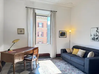 a living room with a blue couch and a desk at Casa Angeli 2 in Rome