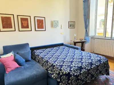 a bedroom with a bed and a blue couch at Casa Angeli 2 in Rome