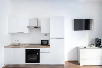 a kitchen with white cabinets and a sink at Vatican Dimora Apartments in Rome