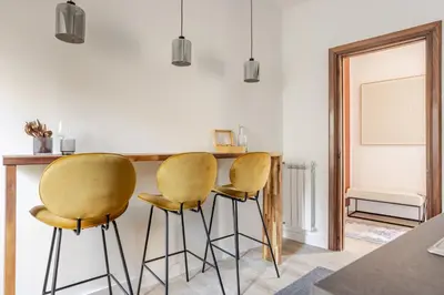 a kitchen with two yellow chairs and a table at Piazza di Spagna 2 Bedrooms and 5 Juliet Balcony in Rome