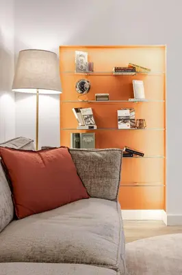 a couch in a living room with an orange wall at Piazza di Spagna 2 Bedrooms and 5 Juliet Balcony in Rome