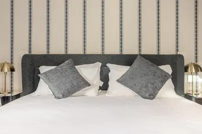 a bedroom with a white bed with gray pillows at Piazza di Spagna 2 Bedrooms and 5 Juliet Balcony in Rome