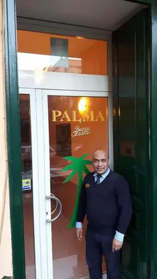 a man in a suit and bow tie standing in front of a building at Palma in Rome
