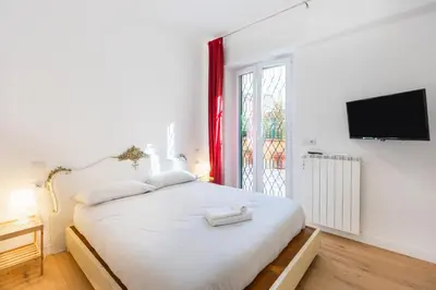 a bedroom with a large white bed and a window at Casa Donna Olimpia Pamphilj in Rome