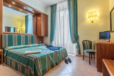 a hotel room with a bed and a desk at Raeli Hotel Siracusa in Rome