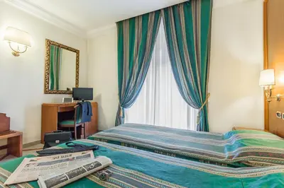 a hotel room with a bed and a window at Raeli Hotel Siracusa in Rome