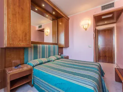 a bedroom with a large bed and a mirror at Raeli Hotel Siracusa in Rome
