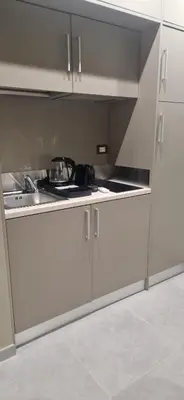 a kitchen with white cabinets and a sink at Roma Suite Style in Rome