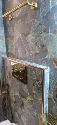 a mirror on a wall with a floral wallpaper at Roma Suite Style in Rome