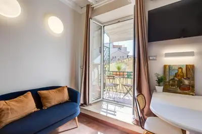 a living room with a blue couch and a large window at Romantic Studio with Balcony near Navona Square in Rome