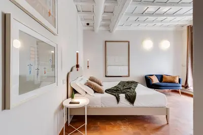a white bedroom with a bed and a chair at Romantic Studio with Balcony near Navona Square in Rome