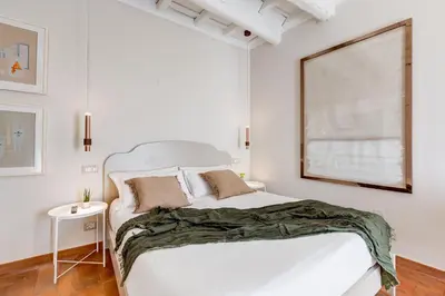 a white bedroom with a white bed and a window at Romantic Studio with Balcony near Navona Square in Rome