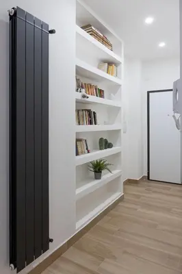 a black sliding door in a room with bookshelves at Cecilia s House in Rome