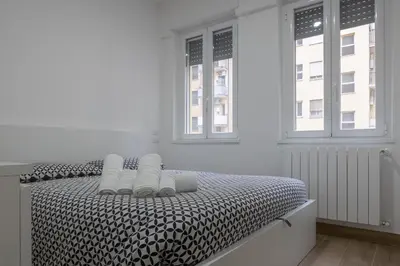 a bedroom with a black and white bed with two windows at Cecilia s House in Rome