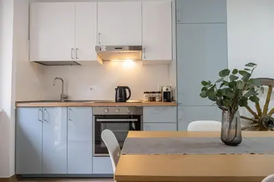 a kitchen with white cabinets and a table with a vase at Cecilia s House in Rome