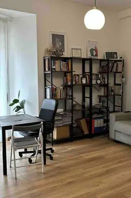 a living room with a table and a book shelf at Casa De Santis in Rome