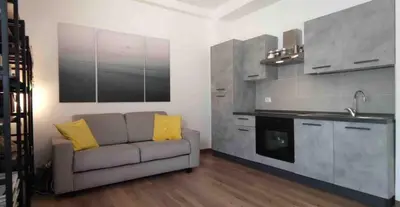 a living room with a couch and a kitchen at Casa De Santis in Rome
