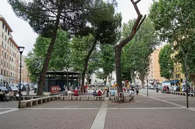 a city street with trees and people sitting on benches at Casa De Santis in Rome