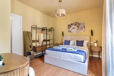 a bedroom with a bed with blue sheets and a table at iFlat Warm & Welcoming Little Gem in Rione Monti in Rome