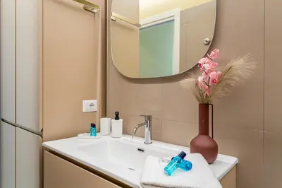 a bathroom with a sink with a mirror and a vase with flowers at iFlat Warm & Welcoming Little Gem in Rione Monti in Rome