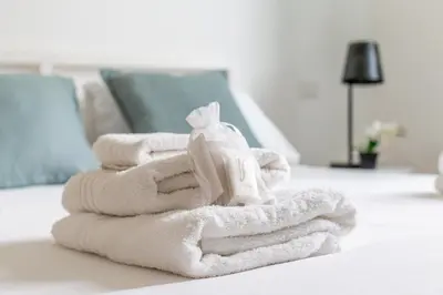 a pile of towels sitting on top of a bed at iFlat Stylish New Flat Steps from the Vatican in Rome