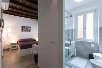 a bathroom with a bed and a sink and a toilet at Domenichino Luxury Home in Rome