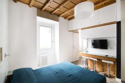 a bedroom with a blue bed and a desk at Domenichino Luxury Home in Rome