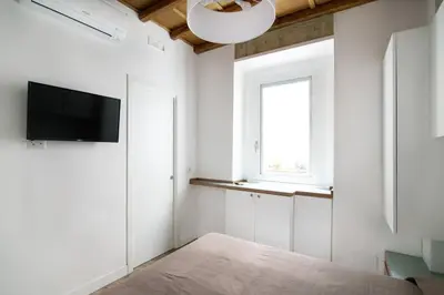a white room with a television and a window at Domenichino Luxury Home in Rome