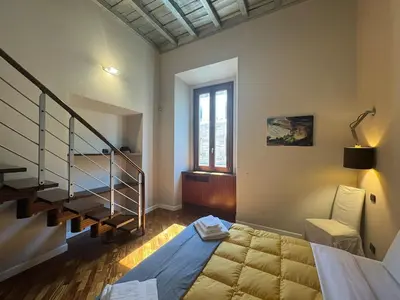 a bedroom with a bed and a stair case at La Dolce Vita in the Ancient Rome in Rome