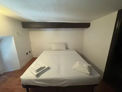 a bed in a room with white sheets and towels at La Dolce Vita in the Ancient Rome in Rome