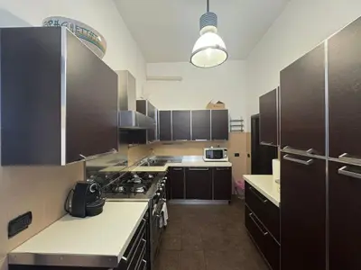 a kitchen with brown cabinets and a stove top oven at La Dolce Vita in the Ancient Rome in Rome