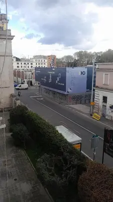 a large blue train traveling down a street at Roma centro little house of testaccio in Rome