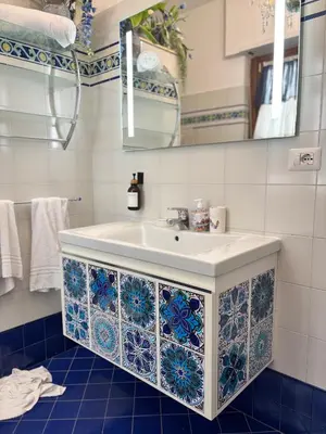 a bathroom with a sink with blue and white tiles at Mami Guest House Rome Vatican St Peters in Rome