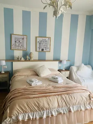 a bedroom with a bed with blue and white stripes at Mami Guest House Rome Vatican St Peters in Rome