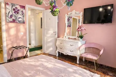 a pink bedroom with a dresser and a mirror at Mami Guest House Rome Vatican St Peters in Rome