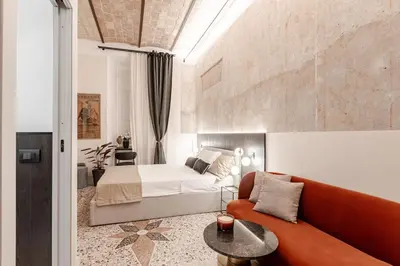 a bedroom with a bed and a couch and a table at En-suite Bedroom Manin - 2 min walk to Termini Station in Rome