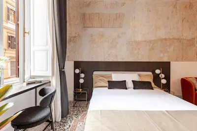 a bedroom with a white bed and a chair at En-suite Bedroom Manin - 2 min walk to Termini Station in Rome
