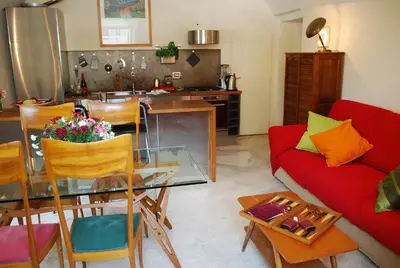 a living room with a table and a red couch at Appartamento Piazza Farnese in Rome