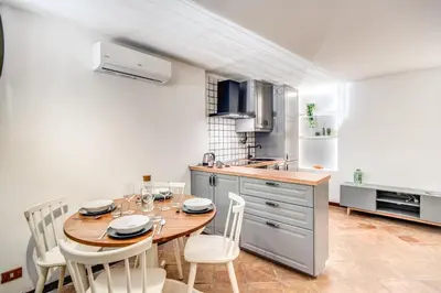 a kitchen with a wooden table and white chairs at Link Campus Apartment in Rome