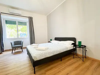 a bedroom with a bed and a chair and a window at Riboty Boutique Rooms in Rome